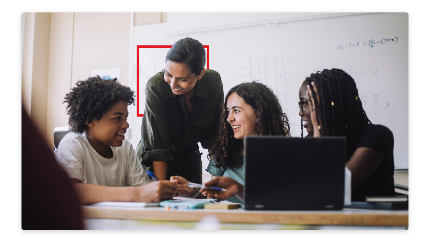 Instructor working with their students with the McGraw Hill cube behind them as a symbol of our support. 